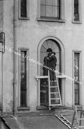 MAN FITTING LEADE GLASS AT RERE OF 35 LEESON STREET